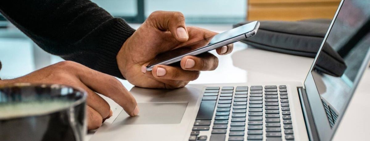 man using laptop and phone to access Chubb Risk Consulting Exchange